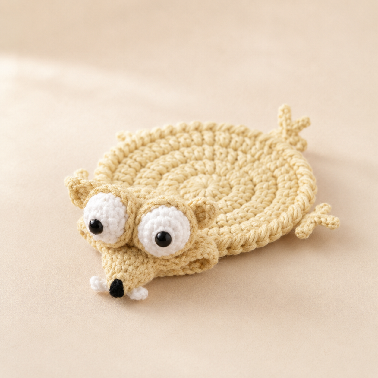 Handmade funny squirrel crochet coaster on a soft beige background